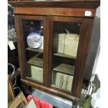 A late Victorian glazed mahogany two door bookcase on later turned legs