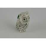 A silver owl pincushion with green eyes