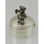 A white metal circular pill box, the lid mounted with an articulated teddy bear, stamped 925 to