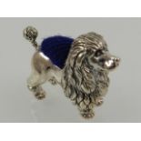 A novelty white metal pin cushion in the form of a poodle.