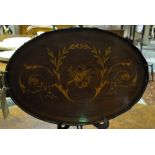 An Edwardian mahogany satinwood marquetry inlaid oval tea tray decorated with musical trophy and