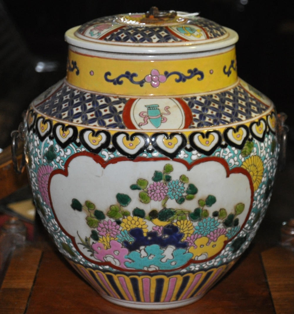 A Chinese earthen ware lidded jar and cover decorated with panels and peony