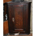 A George III oak hanging corner cupboard, fitted drawer,