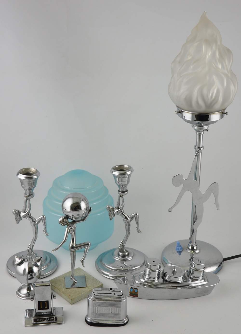 An Art Deco-style chromed table lamp with frosted glass torch shade on circular base,