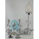 An Art Deco-style chromed table lamp with frosted glass torch shade on circular base,