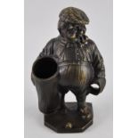 A bronzed metal pipe stand modelled as an elderly golfer,