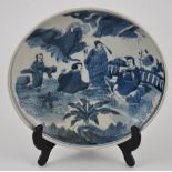 A Chinese blue and white dish decorated with a scene of gentlemen,