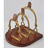 A brass horse shoe shaped stationary rack on leather base