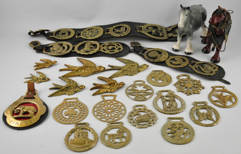 Ten horse brasses on three leather harnesses, together with thirteen further horse brasses,