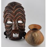 A pre-Columbian clay pot with bird head adornment,