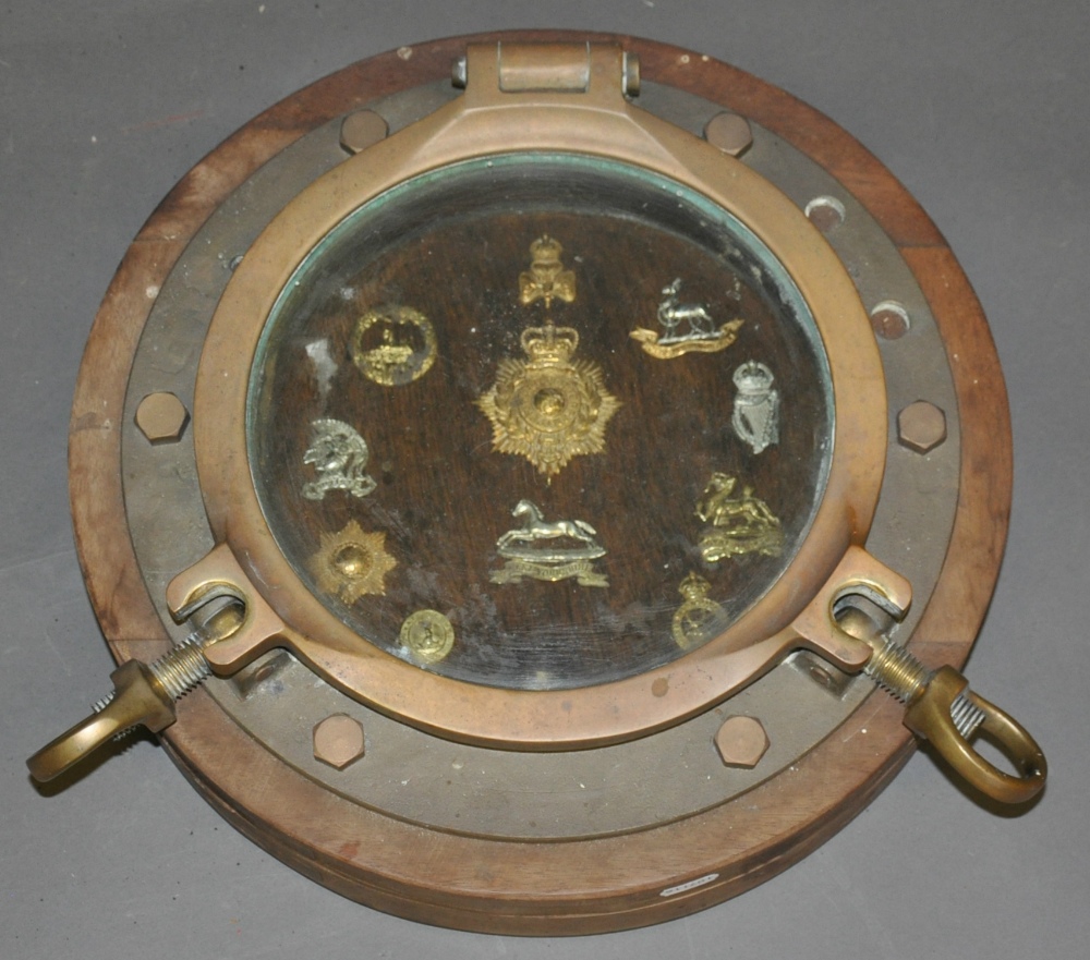 A brass porthole on circular hardwood frame, Dia.