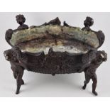 A George III bronze centrepiece/jardiniere of oval form with Rococo decoration and raised on four