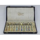 A set of eleven Scandinavian silver gilt and enamel decorated spoons, boxed.