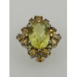 A citrine and silver cluster floral pendant, having a central oval cut stone, stamped 925 to back