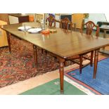 A Charlotte dining table by Oacre, alder wood stained french walnut the top with with rounded