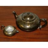 A silver plated squat bullet shaped teapot, together with a cream jug, (2).