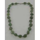 A jade necklace, caved in the form of hearts inter-spaced with smaller beads.