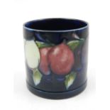 A Moorcroft pottery plum pattern circular pot with mottled blue glazed body,