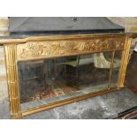 A Victorian gilt framed overmantle mirror, having carved leaf design, flanked by simulated bamboo