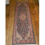 An indigo ground Tabriz runner, decorated with tear drop floral medallion to centre,