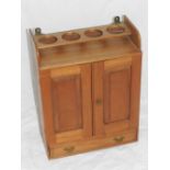 A wall hanging apothecary cabinet, the gallery top with bottle holders, double doors to reveal