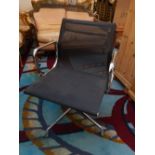 In the manner of Charles Eames, a ribbed black mesh and chrome swivel visitors chair on four prong