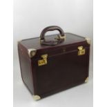 An Etienne Aigner burgandy leather ladies vanity case with key,