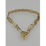 A 9 carat yellow gold bar gate bracelet, with heart-shaped clasp.