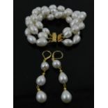 A triple strand South Sea white pearl bracelet, having yellow metal clasp stamped 14K,