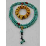 A synthetic turquoise beaded necklace, together with an amber style beaded bracelet.