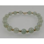 A yellow metal and jade beaded bracelet, the clasp stamped 14K.