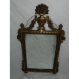 An early 20th century wall mirror, with a vase and swag surmount flanked by swags above a