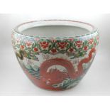 A Chinese porcelain fishbowl, of circular form, with inverted rim, having red and green decoration.