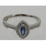 An 18 carat white gold, diamond, and sapphire ring, set marquise cut sapphire, the mount and