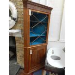 A George III style mahogany standing corner cupboard, the blind fretwork frieze above an astragal