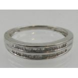 A 14 carat white gold and diamond half eternity ring, having two rows of channel set baguette