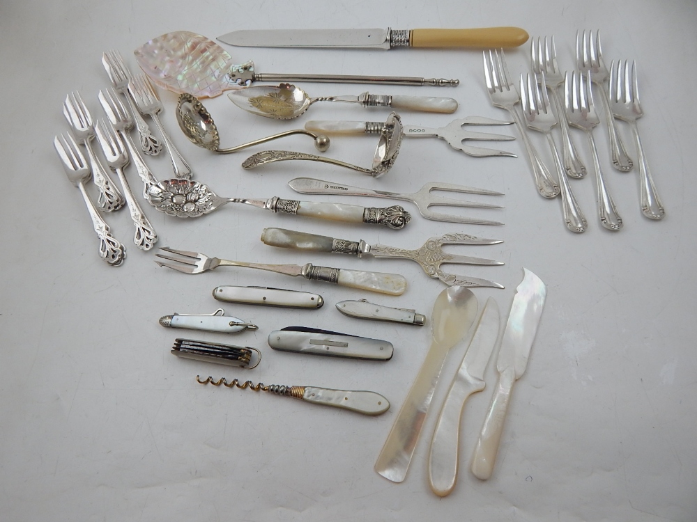 Assorted mother of pearl handled utensils including berry spoon, serving forks,