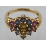 A 9 carat yellow gold and sapphire cluster ring, set blue, green, pink, and yellow sapphires.