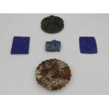 A collection of five Chinese and Eastern carved hardstone disks and pendants.