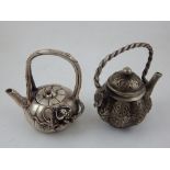 A Chinese ornate white metal teapot, bears four character mark to base,