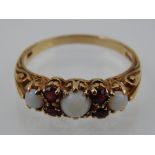 A 9 carat yellow gold, opal, and garnet ring,