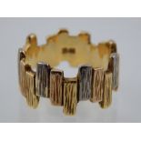 An 18ct three colour gold bark effect band of stave form.