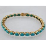 A yellow metal and turquoise articulated bracelet, set oval cabouchon turquoise,