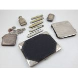 A George V silver mounted, black leather wallet, an engraved silver vesta on chain,