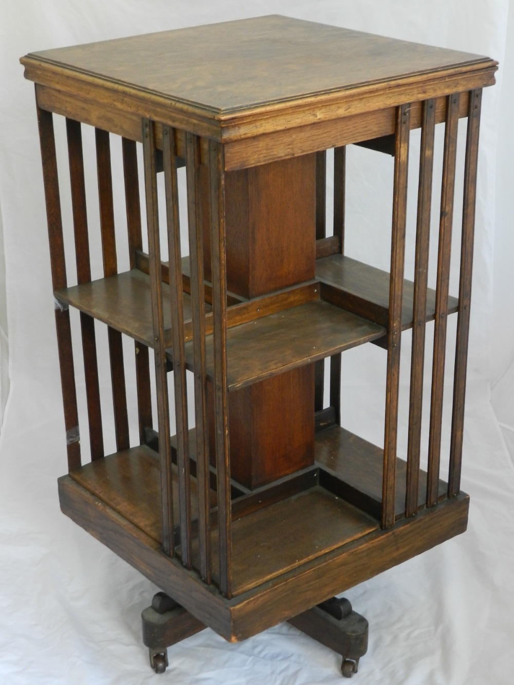 A 1920s oak revolving bookcase, on quadruple platform foot. H.