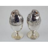 A pair of silver plated egg cups, having lids in the form of chicks with yellow glass eyes.