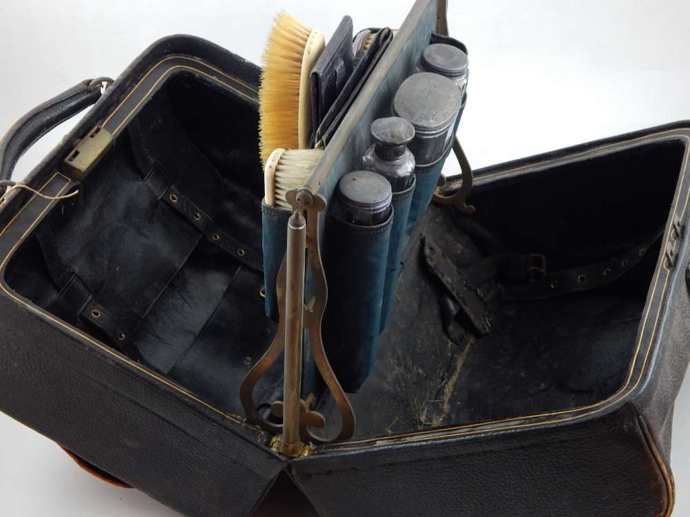 A late 19th century dressing case, black leather Gladstone type,