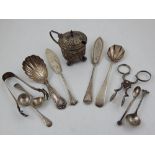 A pair of early 19th century silver sugar nips, a Victorian silver caddy spoon, two butter knives,