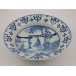 A Chinese blue and white dish, the central panel decorated with a man and woman in a garden setting,