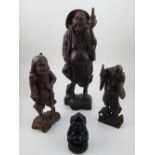 An unusual Chinese carved hardwood figure of a farmer, together with two smaller similar examples,